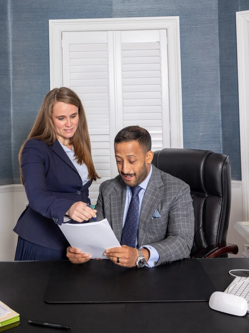 Palacios Law Group attorneys consulting over a client file in the office